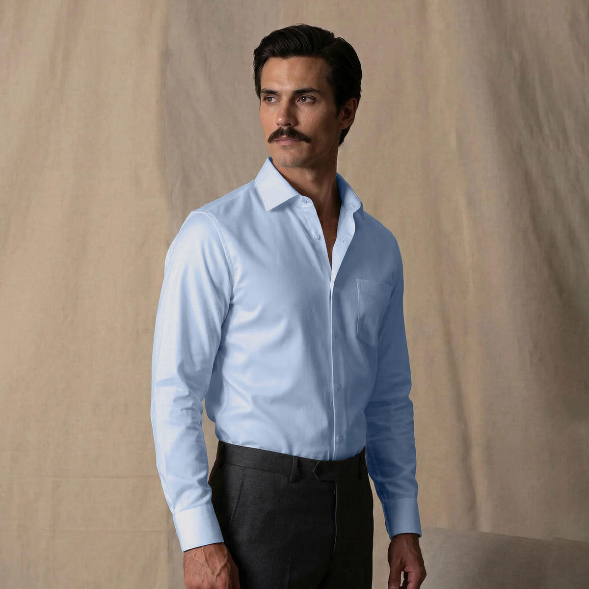 Man wearing a light blue shirt tucked into dark trousers